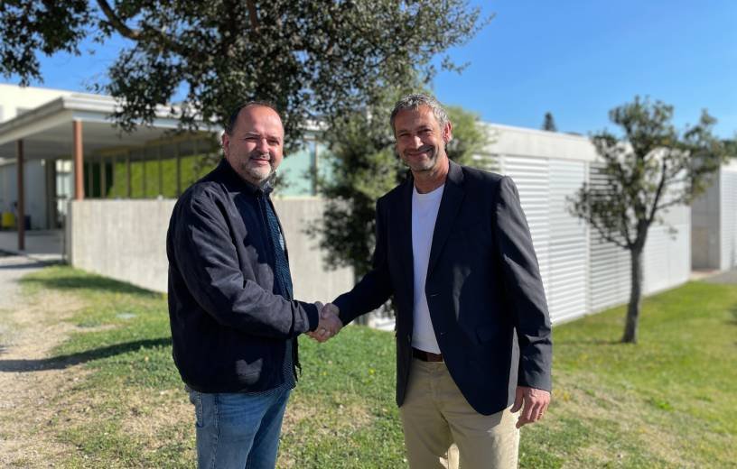 Representants de l’Escola Ginebró i la Fundació REIR donant-se la mà durant la presentació del cicle d’integració social amb pràctiques remunerades